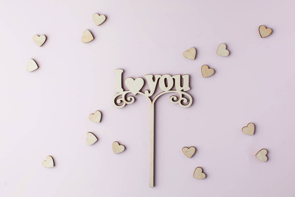 A wooden axe with the words I LOVE YOU on a pink background.  - Fotó, kép