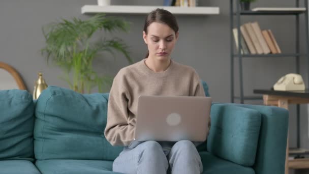 Γυναίκα με φορητό υπολογιστή που έχει πόνο στον καρπό στον καναπέ  - Πλάνα, βίντεο