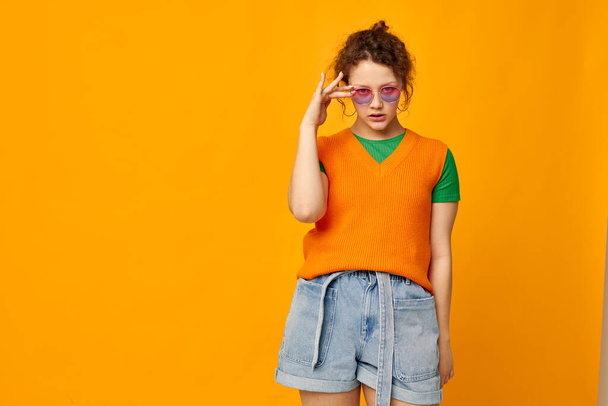 beautiful woman orange sweatshirts sunglasses multicolored glasses supply yellow background unaltered - Фото, изображение