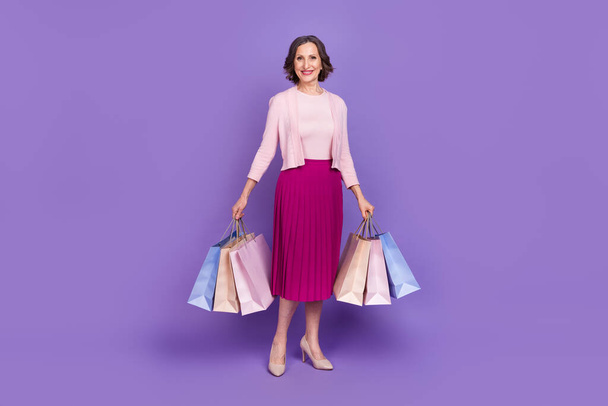 Full length portrait of cheerful pretty person hold packages good mood isolated on purple color background - Fotografie, Obrázek