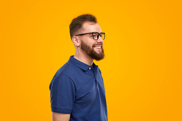 Slimme gelukkige man in bril in studio - Foto, afbeelding