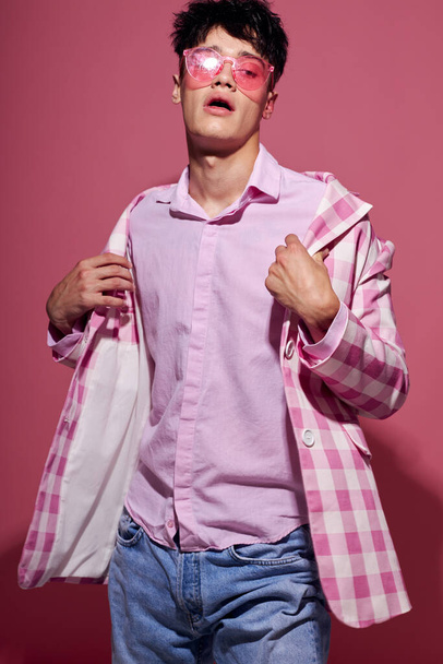portrait of a young man in pink glasses pink blazer posing studio isolated background unaltered - 写真・画像