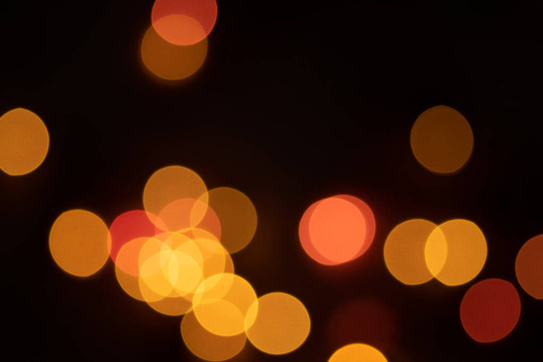 Defocused bokeh lights on black background, an abstract naturally blurred backdrop - Photo, Image