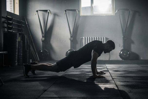 Esportista faz exercícios no Big Dark Gym . - Foto, Imagem