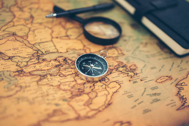 Magnetic compass, magnifying glass and diary on world map. Travel , Adventure and Discovery concept. - Фото, зображення