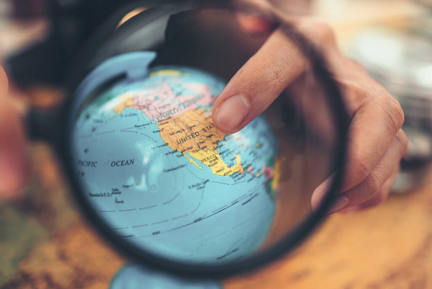 Globe, whole world  and finger point to United states country . The route map on the table. Travel , Adventure and Discovery concept. - Photo, Image
