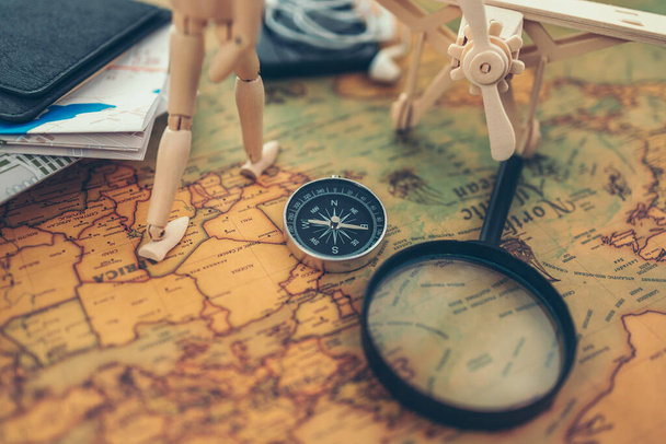 Magnifying glass, Magnetic compass, travel book and wood doll  on world map. Travel , Adventure and Discovery concept. - Photo, image