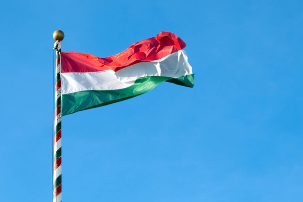 Hungarian flag or flag of Hungary waving against blue sky, space for text	 - Fotó, kép