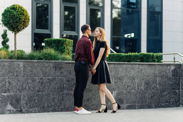 Young romantic couple outdoors. A man and a woman holding hands have a pleasant time together on the eve of Valentine's Day. Two lovers hug and kiss on Valentine's Day. - 写真・画像