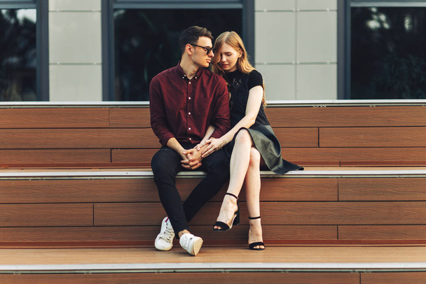 Romantic couple in love look at each other, on vacation enjoy moments of happiness. man and woman are sitting on the stairs outdoors enjoying time together. dating, romance. Valentine's Day - Fotoğraf, Görsel