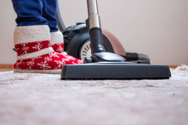 Mulher usando um aspirador de pó para limpar o tapete. Ela está limpando a casa onde há excesso de poeira. - Foto, Imagem