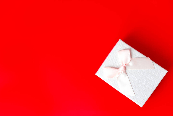 Подарункова коробка на червоному тлі. Романтичний день святого Валентина концепція вітання. місце для вашого тексту
 - Фото, зображення