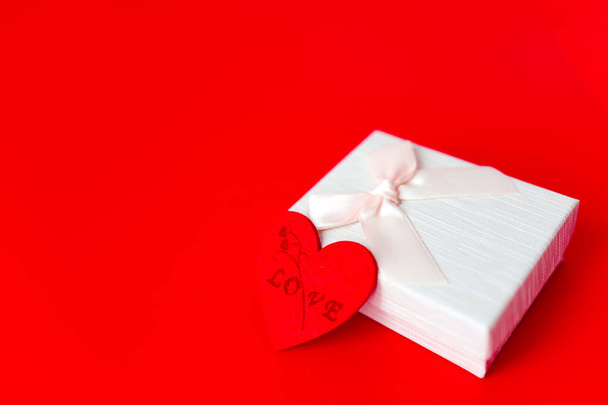 Κουτί δώρου σε κόκκινο φόντο. Ρομαντικό Αγίου Βαλεντίνου έννοια της ημέρας των χαιρετισμών. θέση για το κείμενό σας - Φωτογραφία, εικόνα