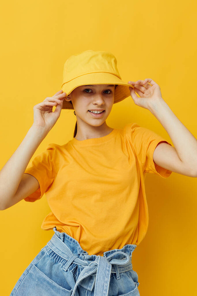 attractive woman in a yellow hat Youth style casual wear yellow background - 写真・画像