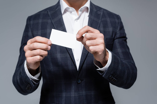 partial view of businessman in checkered blazer holding blank card isolated on grey - Photo, image
