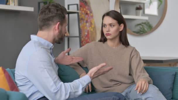 Hombre serio hablando con la mujer mientras está sentado en el sofá
  - Metraje, vídeo