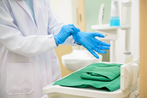 Vrouwelijke tandarts met medische handschoenen Bereid u voor om te werken in een tandheelkundige kliniek, tandheelkundige concepten en gezondheidszorg. - Foto, afbeelding