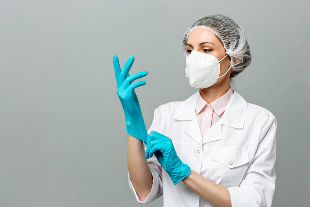 Ritratto di una giovane donna infelice con una maschera medica su sfondo grigio. I dottori hanno gli occhi stanchi. Il concetto di coronavirus. - Foto, immagini
