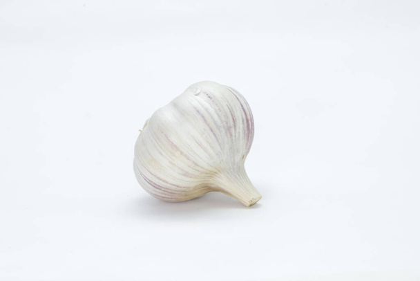 Head of garlic (Allium sativum) with its units still in the bulb and husk on a neutral background - Fotó, kép