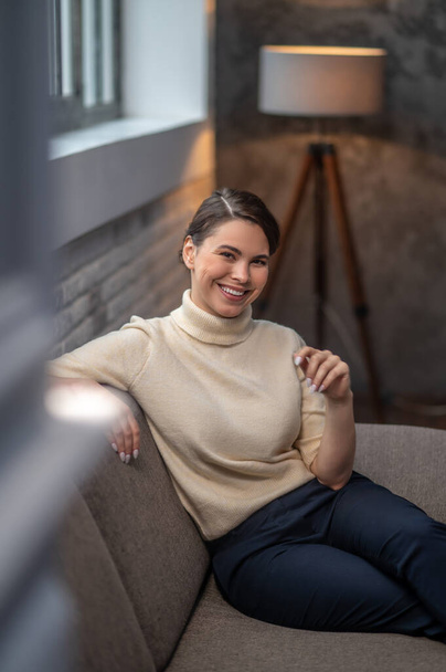 Female with a radiant smile sitting in a room - Valokuva, kuva