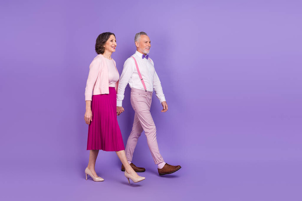 Full size profile portrait of two peaceful persons hold arms look empty space isolated on violet color background - Foto, imagen