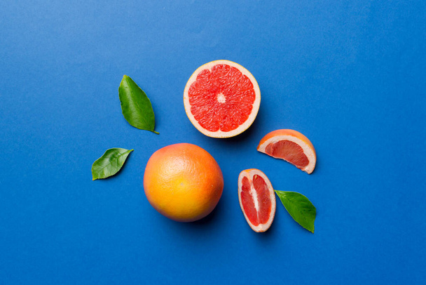 friss gyümölcs grapefruit lédús grapefruit szeletekkel, színes háttérrel. Első látásra. Fénymásolási tér. kreatív nyári koncepció. Fele citrus minimális lapos feküdt másolási hellyel. - Fotó, kép