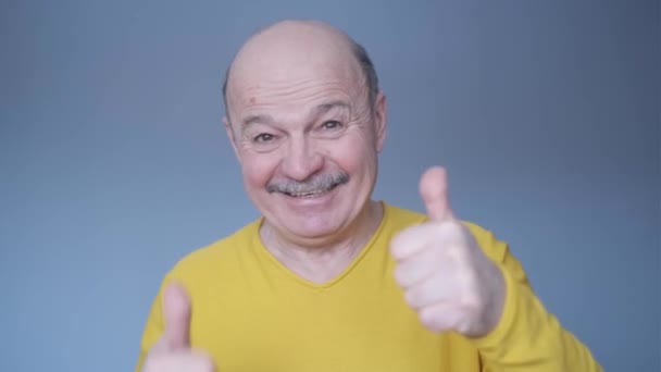 Senior man doing positive gesture with hand, thumbs up smile and happy. - Záběry, video