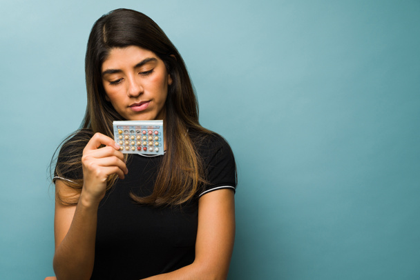 Gynekologický koncept. Zdravá žena drží puchýř antikoncepčních pilulek. Mladá žena užívá antikoncepční pilulky - Fotografie, Obrázek