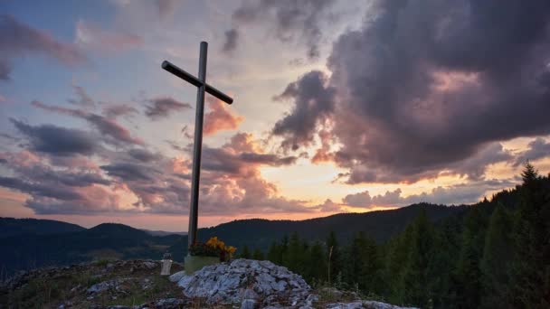 Krzyż chrześcijański na skale o zachodzie słońca - Materiał filmowy, wideo