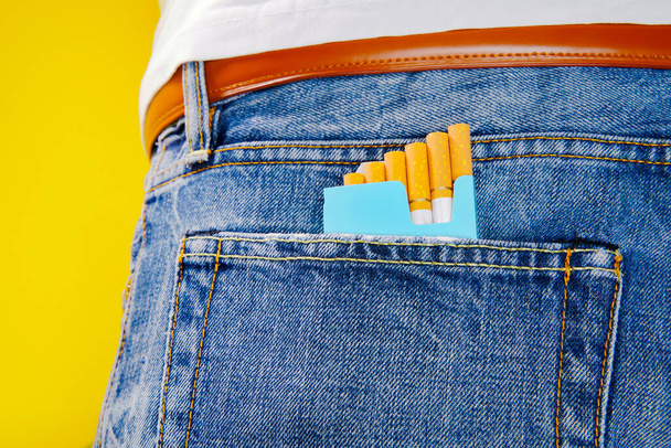 Kot pantolonun içinde bir paket sigara. Gençler pantolonlarında bir paket sigara taşıyor..  - Fotoğraf, Görsel
