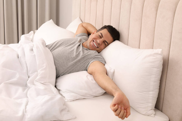 Happy man awakening in bed at home - Foto, Imagem