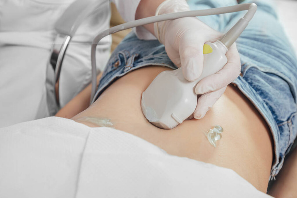 Young woman undergoing ultrasound scan in clinic - Zdjęcie, obraz