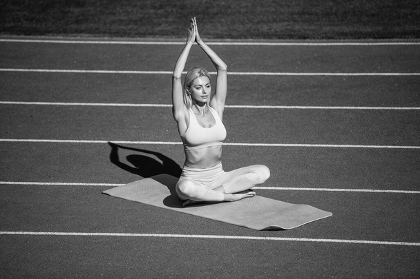 Challenging herself. sexy fitness woman in sportswear. athletic female practice yoga on stadium. stretch sport workout. pilates trainer. yogi coach training. perfect body shape. mind and body balance - Foto, Imagen