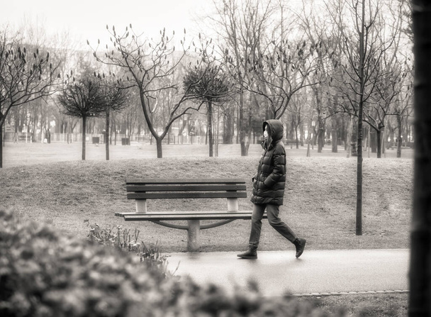 Lonely girl walking or strolling in the park on a foggy morning. - Φωτογραφία, εικόνα