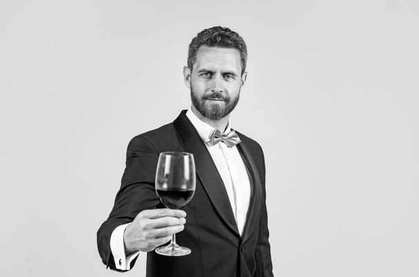 man wear office costume. formal event. businessman drink red wine. cheers for happy valentines day. alcohol drinking. handsome male on romantic date. unshaven man with wine glass. sommelier - Fotó, kép