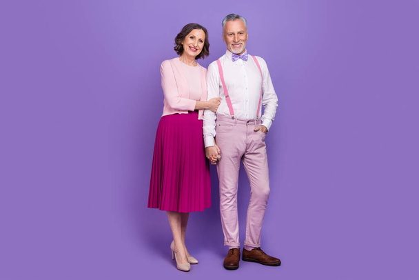 Full length photo of two peaceful idyllic partners hold hands enjoy weekend isolated on purple color background - Фото, изображение