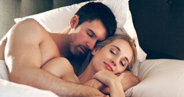 Kollarında rahat uyuyor. Sevecen genç bir çiftin yatakta yatarken yüksek açılı fotoğrafı.. - Fotoğraf, Görsel