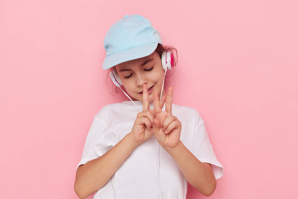 Portrait of happy smiling child girl listening to music on headphones isolated background - Φωτογραφία, εικόνα