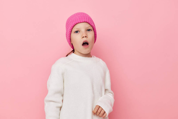 girl in a white sweater with a pink hat on her head - Fotoğraf, Görsel