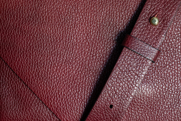 Genuine leather of burgundy color. Natural textured leather background with shoulder strap. copy space - Photo, Image