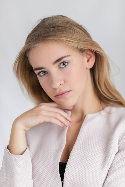 Confident good-looking beautiful woman with blonde dyed hair with healthy pure skin dressed in casual clothes looking seriously at camera. Youth and beauty concept - Фото, зображення