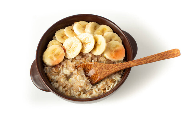 健康的な朝食。白い背景に隔離されたバナナとオートミール。バナナをボウルに入れたオートミール - 写真・画像