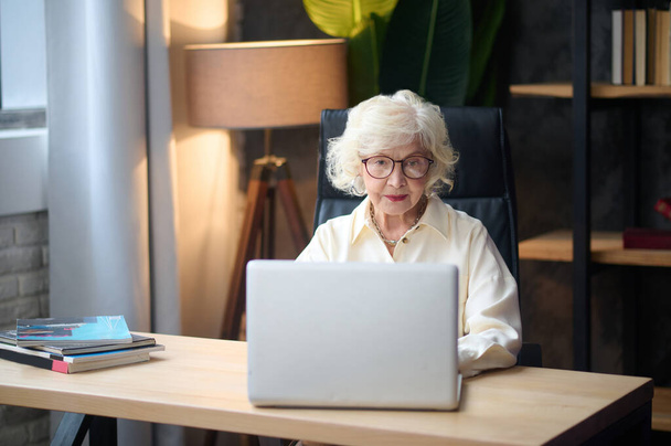 Žena pracující na notebooku sedí u stolu - Fotografie, Obrázek