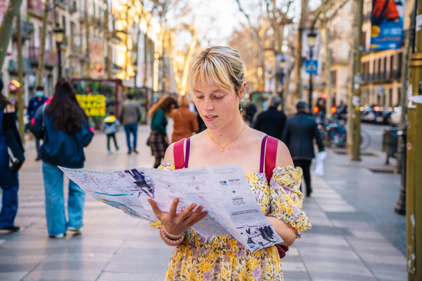 Frau überprüft Standort auf Karte auf überfüllter Straße - Foto, Bild