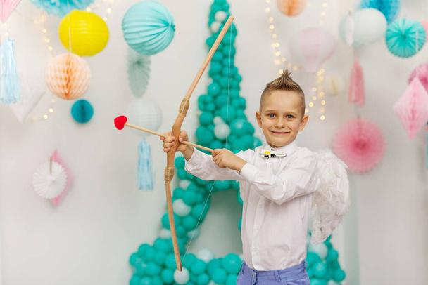 Купидон милый маленький мальчик с крыльями, стрелами и луком. День Святого Валентина - Фото, изображение