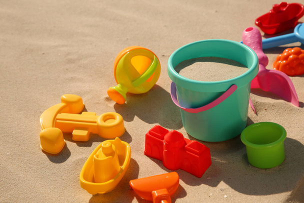 Set of plastic beach toys on sand, space for text. Outdoor play - 写真・画像