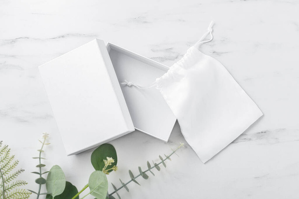 White box and fabric bag, product package mockup on marble table, top view - Foto, Bild