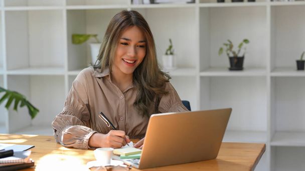 Çekici Asyalı kız üniversite öğrencisi online ödevini dizüstü bilgisayarında yapıyor.. - Fotoğraf, Görsel