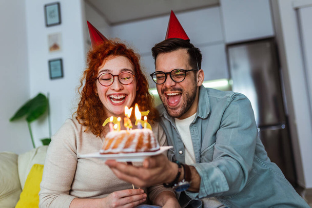 Family couple in party hats celebrating birthday at home - Photo, Image