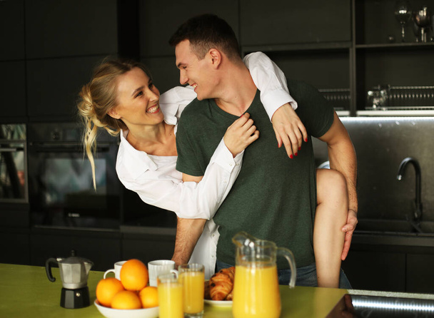 Lifestyle and people concept: Young happy lovely couple have breakfast in the early morning at home, hug, smile. - Φωτογραφία, εικόνα